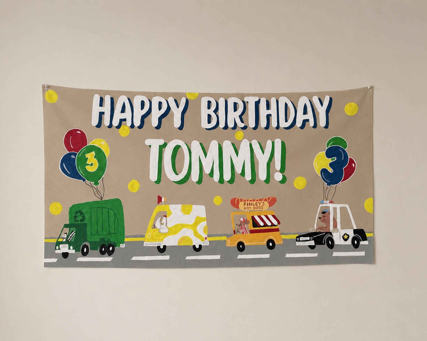 Hand-painted birthday banner for Tommy with trucks, balloons and a hot dog cart