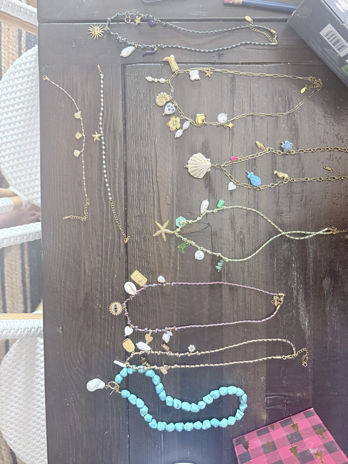 Charm necklaces made at a beading party, laid out on a farmhouse table